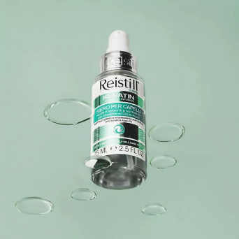 Reistill Keratin Infusion Hair Serum 75 ml floating on mint background with water drops – hydrating keratin and argan oil treatment for damaged hair
